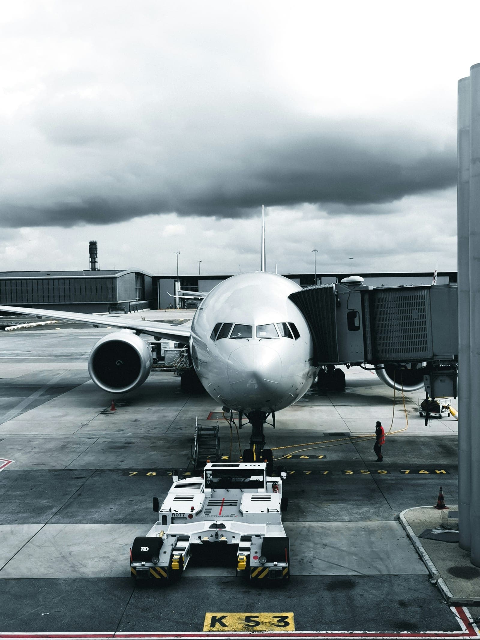 A Boeing airliner at the gate with ground equipment positioned around it