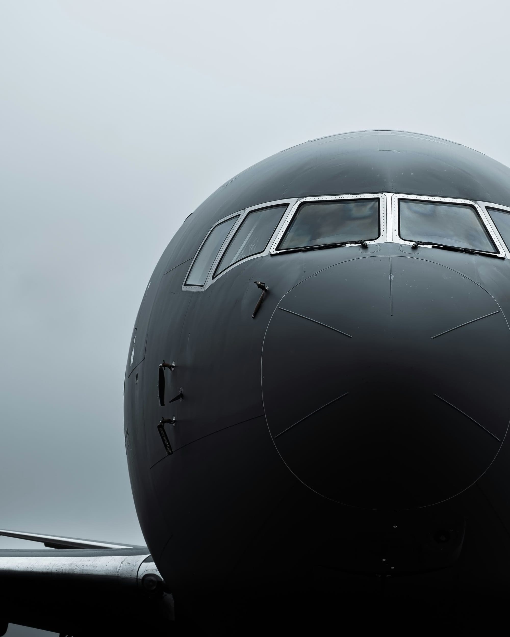 Nose section of a Boeing airliner on a grey ramp morning